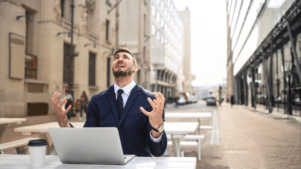 a person in a suit sitting at a table with a laptop