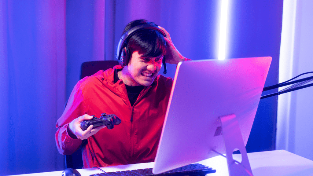 a person in a red shirt is sitting in front of a computer with headphones on