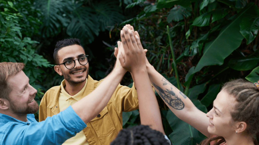 a group of people holding hands in a greenhouse