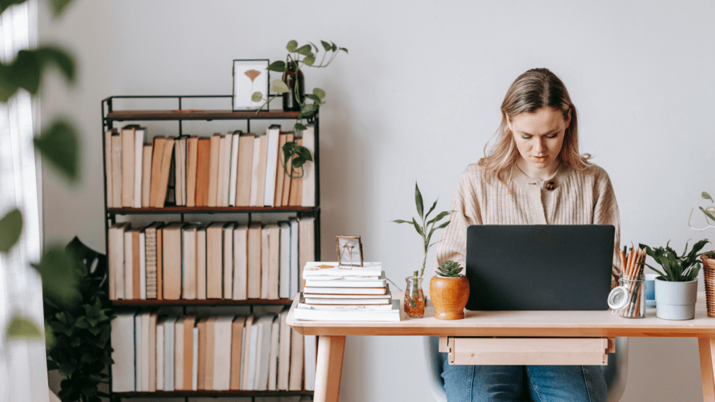 a person sitting at the table working on a laptop