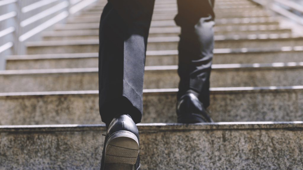 a person in a suit and tie walking up a set of stairs