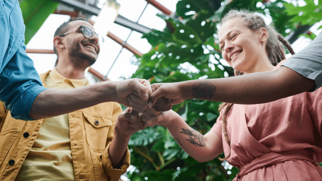 a group of people holding hands in a greenhouse