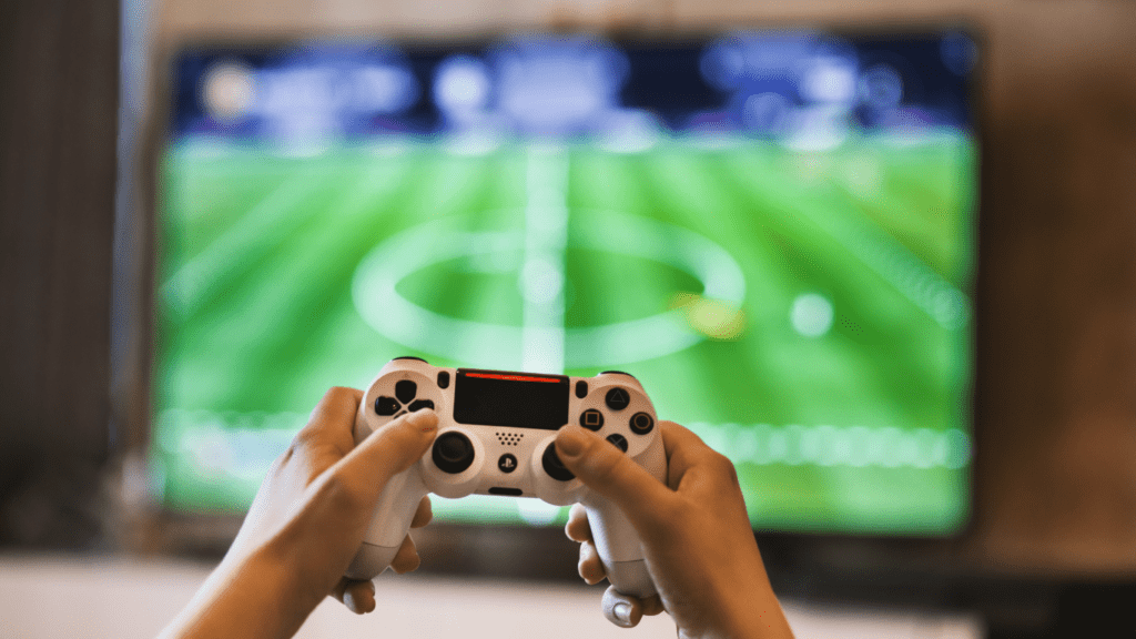 a person holding a video game controller in front of a television