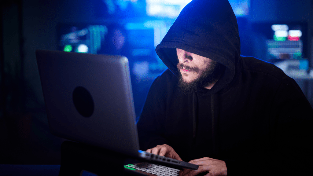 a person sitting at a computer in a dark room