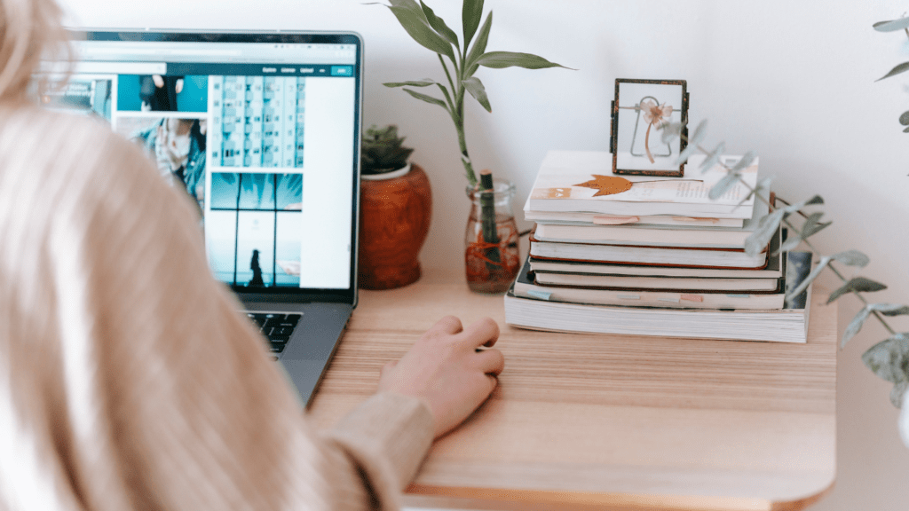 a person sitting at the table working on a laptop